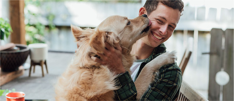 Man being hugged and licked by his dog
