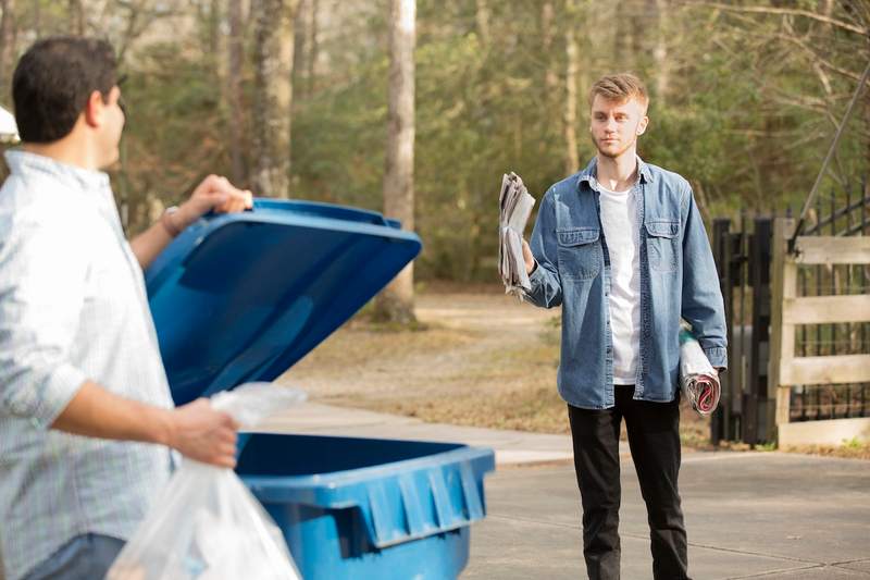 The beginning of an HOA horror story between two neighbors next to a recycling bin at the curb.