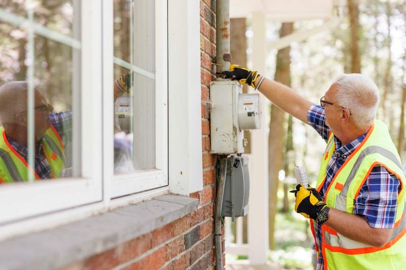 Home inspector examines electricity meter.