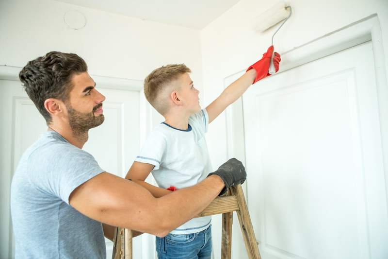 Father and son paint the interior walls of their home.