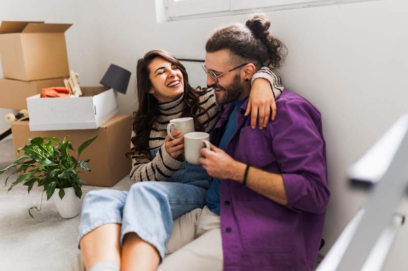 Happy couple drinks their first cup of coffee in their new home.