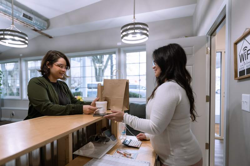 A woman uses her credit card to pay for a purchase in a store.