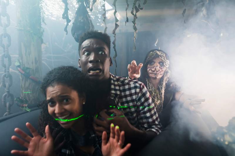 Woman dressed as a zombie chases a frightened couple.